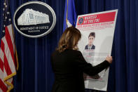 Department of Justice staffer installs a poster of a suspected Russian hacker before FBI National Security Division and the U.S. Attorney's Office for the Northern District of California joint news conference at the Justice Department in Washington, U.S., March 15, 2017. REUTERS/Yuri Gripas