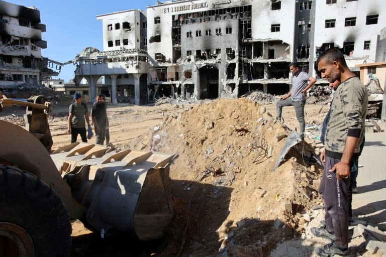 Des personnes recherchent des corps avec un bulldozer à l'hôpital al-Chifa de la ville de Gaza le 8 mai 2024 (-)