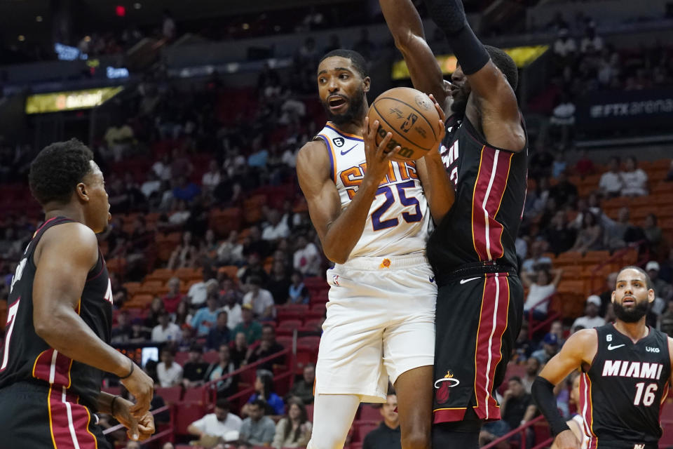 Phoenix Suns forward Mikal Bridges (25) looks to pass the ball as Miami Heat center Bam Adebayo (13) defends during the first half of an NBA basketball game Monday, Nov. 14, 2022, in Miami. (AP Photo/Marta Lavandier)