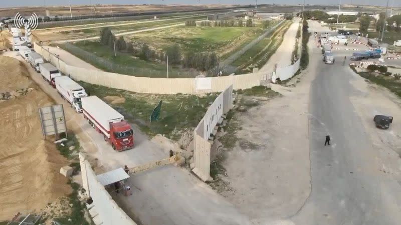 Humanitarian aid trucks wait in line to be inspected at the Kerem Shalom crossing