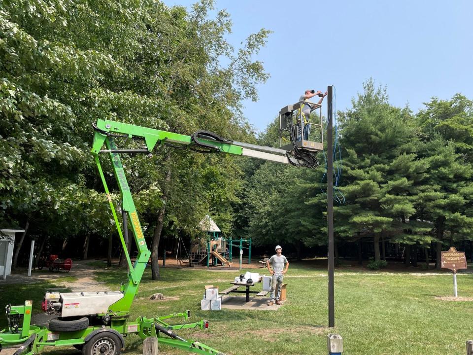 Workers from Steve Essenburg Electric of Hudsonville install cameras for Laketown Township on Tuesday, July 25, at Wolters Woods.