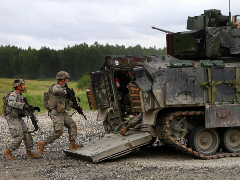 US soldiers load up into their M2 Bradley Fighting vehicle after clearing their first objective during a fire team live-fire certification training as part of Exercise Combined Resolve II at the Joint Multinational Readiness Center in Hohenfels, Germany, June 20, 2014.
