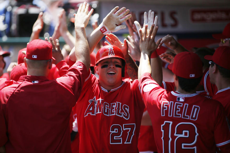 FILE - In this April 20, 2013, file photo, Los Angeles Angels' Mike Trout celebrates with teammates as he returns to the dugout after hitting a grand slam off Detroit Tigers starting pitcher Rick Porcello during the first inning of a baseball game in Anaheim, Calif. Trout was the lone player to show up at the first baseball draft held in Secaucus, N.J. (AP Photo/Danny Moloshok, File)