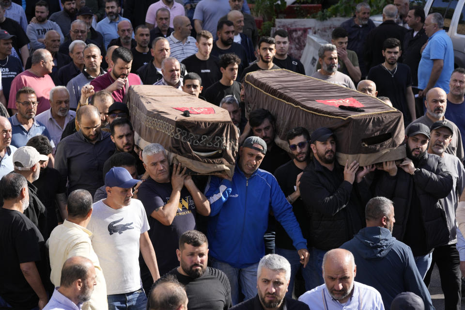 Mourners carry the coffins of two victims who were among four civilians from the same family that killed on Sunday by Israeli strikes on the southern town of Mays al-Jabal, during their funeral procession, in Beirut, Monday, May 6, 2024. Hezbollah militants and Israeli forces have been exchanging fire in south Lebanon since a day after the Israel-Hamas war began on Oct. 7. (AP Photo/Hussein Malla)