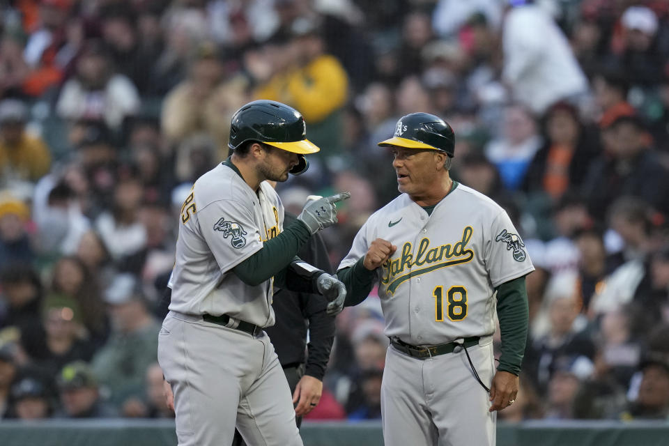Oakland Athletics' Shea Langeliers, left, celebrates with first base coach Mike Aldrete after hitting an RBI single against the San Francisco Giants during the fourth inning of a baseball game Wednesday, July 26, 2023, in San Francisco. (AP Photo/Godofredo A. Vásquez)