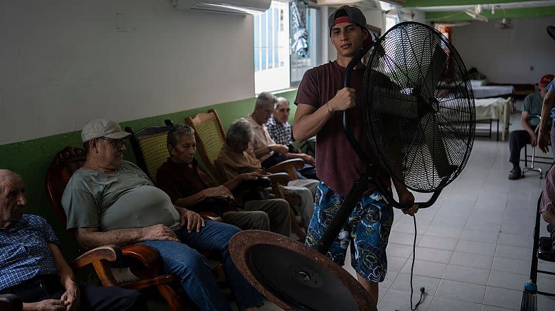 Humanitarian worker Roger Duvan Lagunes carries a fan into the Cogra, an elderly shelter, in Veracruz, Mexico, on 16 June 2024.