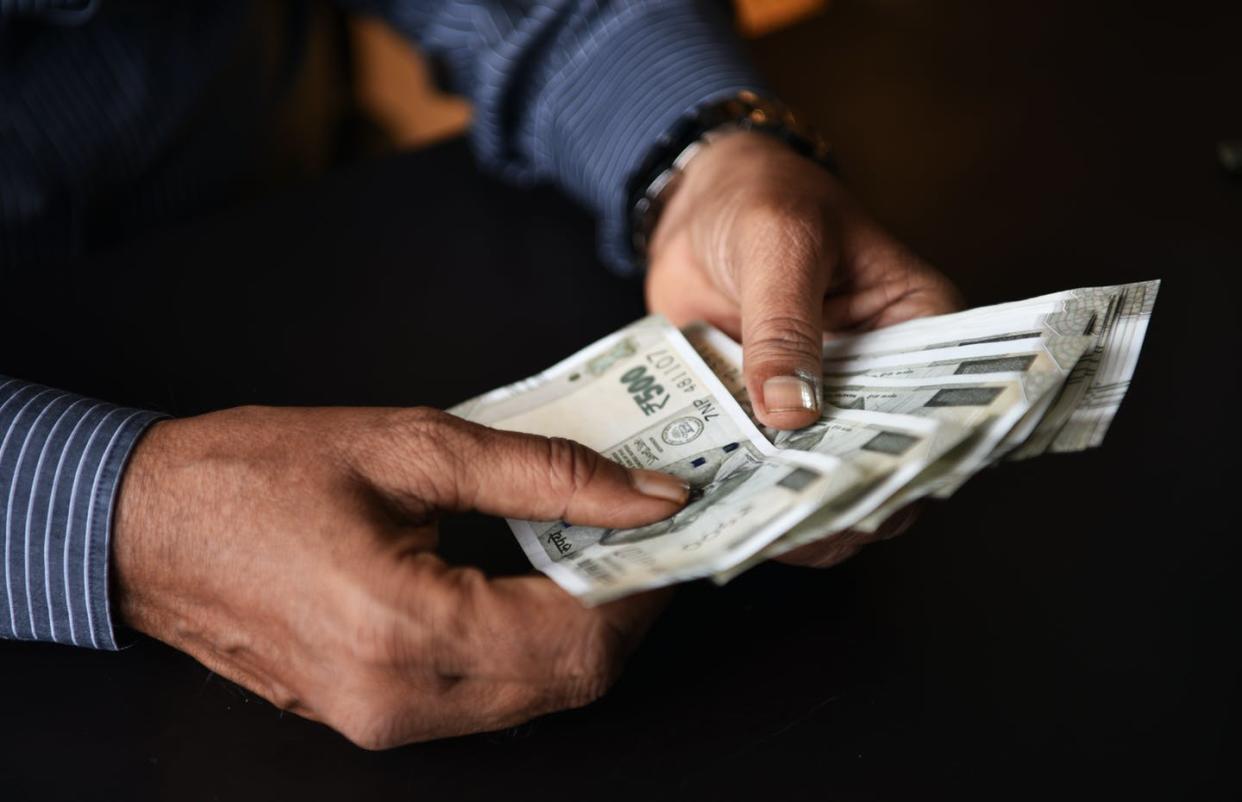 <span class="caption">More governments and aid organizations are giving poor people cash.</span> <span class="attribution"><a class="link " href="https://www.gettyimages.com/detail/photo/closeup-of-a-hands-of-a-man-holding-indian-rupee-royalty-free-image/1008274522" rel="nofollow noopener" target="_blank" data-ylk="slk:Mayur Kakade/Moment via Getty Images;elm:context_link;itc:0;sec:content-canvas">Mayur Kakade/Moment via Getty Images</a></span>