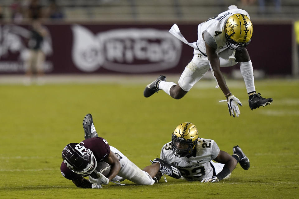 Vanderbilt's Randall Haynie (4) leaps to avoid Jaylen Mahoney (23) and Texas A&M's Chase Lane (2) during the second half of an NCAA college football game Saturday, Sept. 26, 2020, in College Station, Texas. Texas A&M won 17-12. (AP Photo/David J. Phillip)