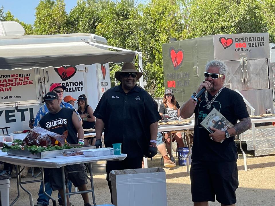 Chef Kevin Bludso, second to the right, gifted Food Network host Guy Fieri a copy of his book, "Bludso's BBQ Cookbook: A Family Affair in Smoke and Soul," during the Stagecoach Smokehouse on Saturday, April 30, 2022.