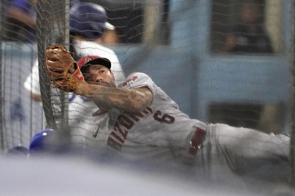 Arizona Diamondbacks third baseman Jace Peterson crashes into the netting after making a catch on a ball hit by Los Angeles Dodgers' Jason Heyward during the first inning of a baseball game Monday, Aug. 28, 2023, in Los Angeles. (AP Photo/Mark J. Terrill)