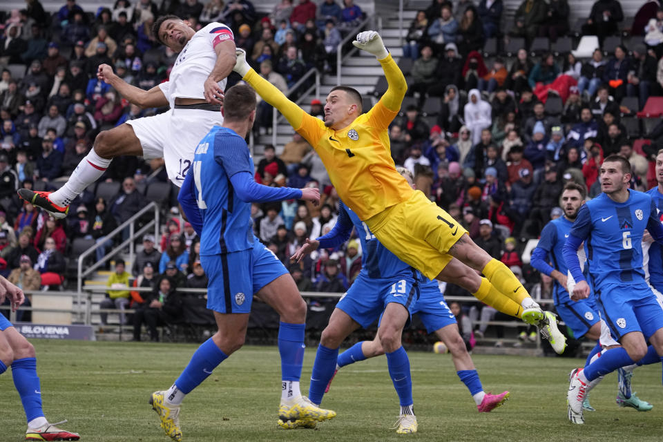 Slovenia goalkeeper Igor Vekic (1) and Klemen Mihelak defend a cross as United States' Miles Robinson (12) tries for a header during the first half of an international friendly soccer match in San Antonio, Saturday, Jan. 20, 2024. (AP Photo/Eric Gay)