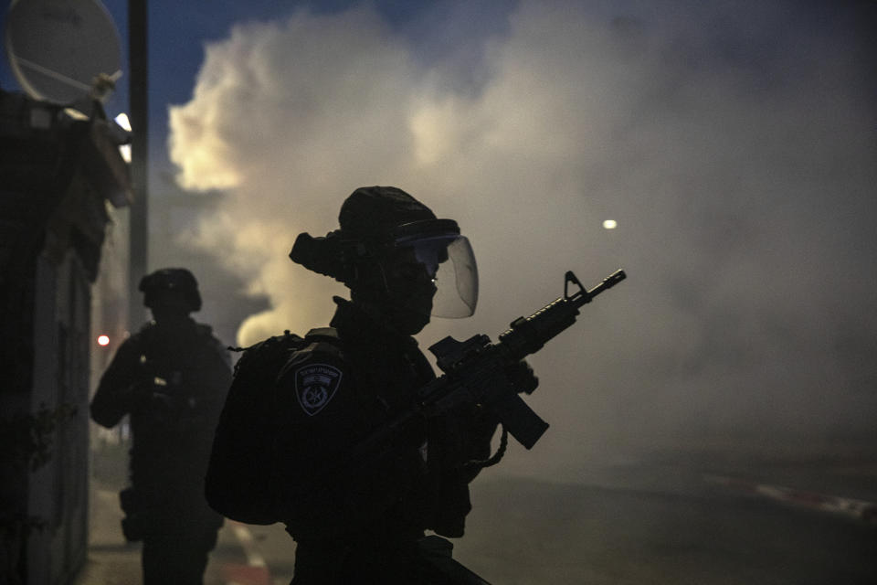 Israeli forces run during clashes with Israeli Arabs in the Israeli mixed city of Lod, Israel, Tuesday, May 11,2021. (AP Photo/Heidi Levine)