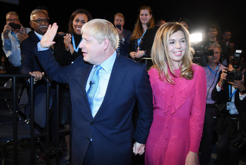 Britain's Prime Minister Boris Johnson leaves the stage after he finishes his Leader's speech and joins his girlfriend Carrie Symonds, during the Conservative Party Conference in Manchester, England, Wednesday, Oct. 2, 2019. (Jeremy Selwyn/Pool via AP)