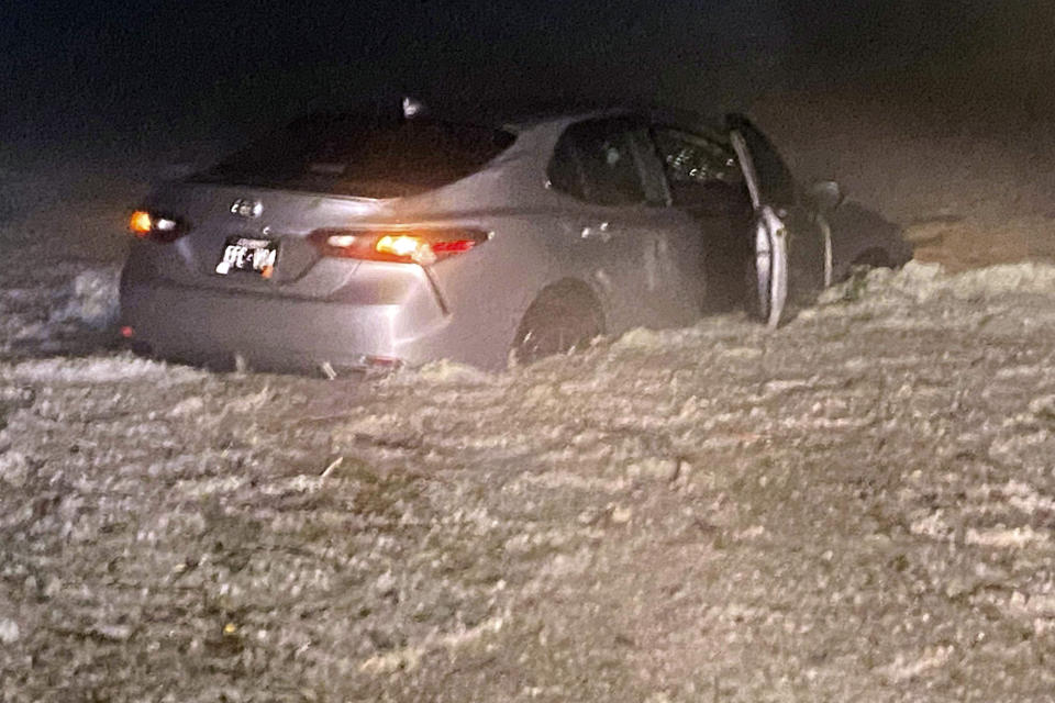 This image provided by JJ Unger, shows hail surrounding a vehicle, Monday night, May 20, 2024, in Yuma, Colo. Residents in the small city in northeastern Colorado were cleaning up Tuesday after hail the size of baseballs and golf balls pounded the community, with heavy construction equipment and snow shovels being used to clear hail that had piled up knee-deep the night before. (JJ Unger via AP)