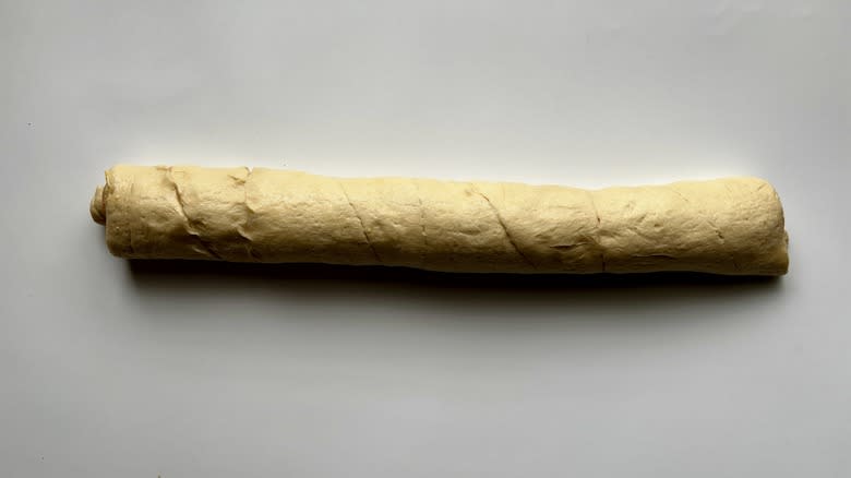 a rolled up log of croissant dough 
