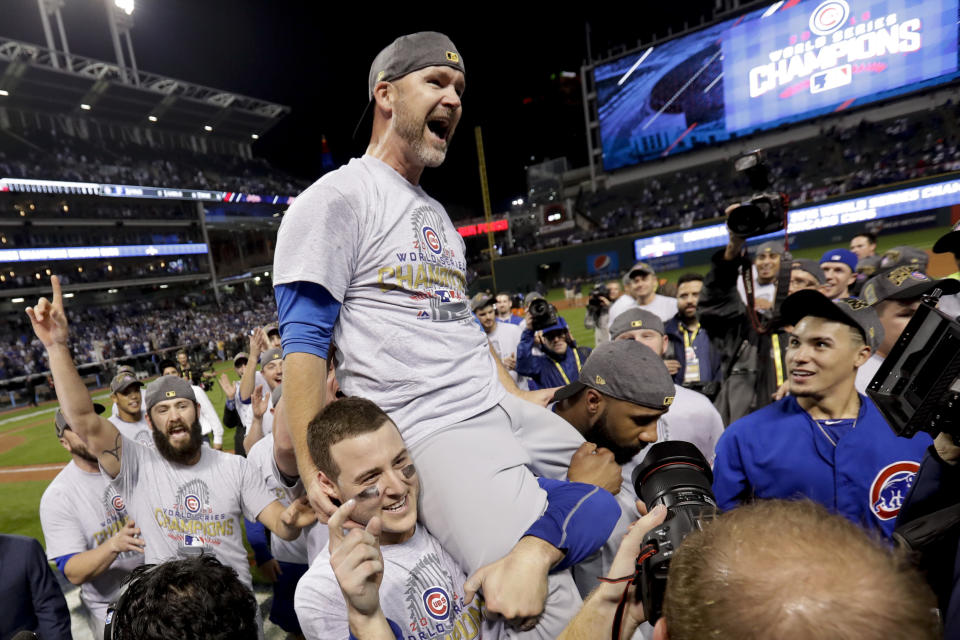 FILE- In this Nov. 3, 2016, file photo, Chicago Cubs catcher David Ross is carried by teammates after Game 7 of the Major League Baseball World Series against the Cleveland Indians in Cleveland. The Chicago Cubs have hired former catcher David Ross to replace Joe Maddon as their manager, hoping he can help them get back to the playoffs after missing out for the first since 2014. (AP Photo/Matt Slocum, File)