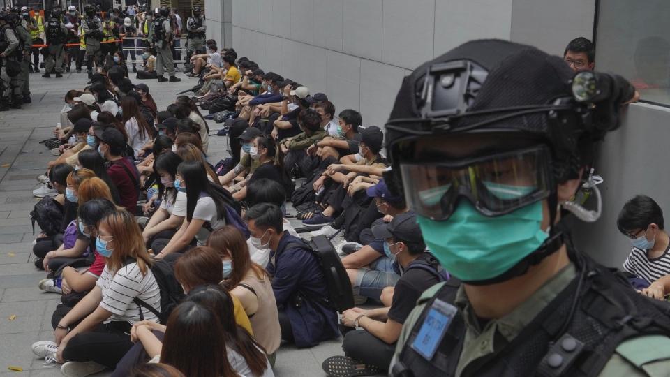 Von Bereitschaftspolizisten festgehaltene regierungskritische Demonstranten im Zentrum von Hongkong.