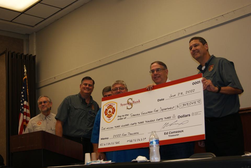 Danny Cavell, second from the right, holds the earnings from this year's Thibodaux Firemen's Fair. He was awarded the honorary red grand marshal coat at the department's annual banquet Thursday, June 23, 2022 at the Warren J. Harang Municipal Auditorium.