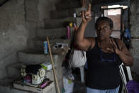 Seamstress Vania da Silva, 62, a member of the Unidos de Padre Miguel samba school, points to a wall inside her home, damaged by stray bullets, in Rio de Janeiro, Brazil, Monday, Sept. 21, 2020. Rio’s League of Samba Schools, LIESA, announced that the spread of the coronavirus has made it impossible to safely hold the traditional parades that are a cultural mainstay and, for many, a source of livelihood. (AP Photo/Silvia Izquierdo)