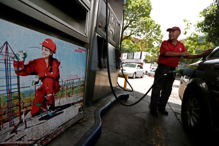 A worker pumps fuel into a vehicle at a state oil company PDVSA's gas station in Caracas, Venezuela May 17, 2019. REUTERS/Ivan Alvarado