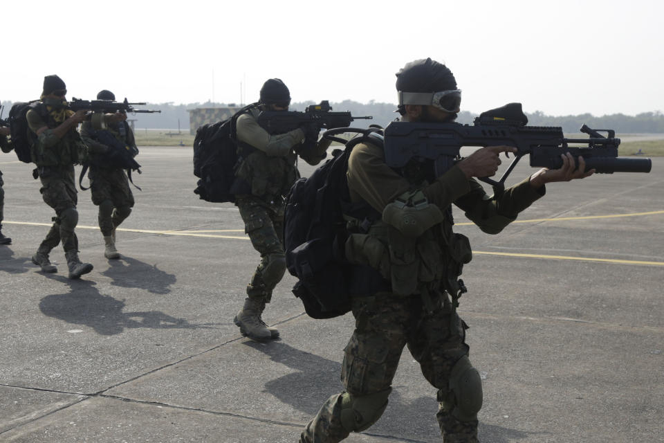 FILE - In this Dec. 10, 2018, file photo, Indian special force commandos take position after landing on a runway from a moving C-130 transport aircraft during India -U.S. joint air force drills at Air Force Station Kalaikunda, India. India has high hopes its ties with the United States will deepen under President Joe Biden, who was a key proponent of the 2008 civil nuclear deal between the countries and whose new administration includes several Indian Americans. (AP Photo/Bikas Das, File)