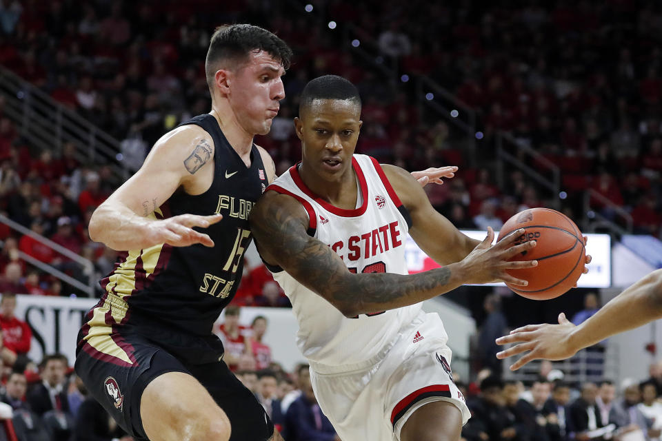 North Carolina State's C.J. Bryce, right, drives the ball around Florida State's Dominik Olejniczak (15) during the first half of an NCAA college basketball game in Raleigh, N.C., Saturday, Feb. 22, 2020. (AP Photo/Karl B DeBlaker)