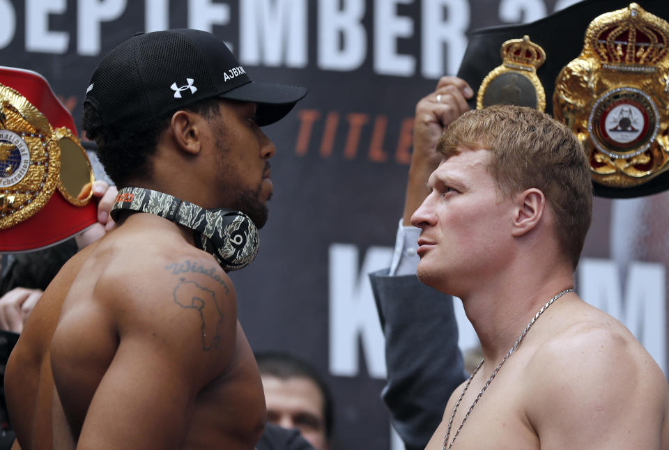 Britain's Anthony Joshua, left, and Russia's Alexander Povetkin pose during the weigh-in at the Business Design Centre in London, Friday, Sept. 21, 2018. Anthony Joshua and Alexander Povetkin are due to fight for the WBA, IBF, WBO and IBO heavyweight title in a boxing match on Saturday Sept. 22, 2018 at Wembley stadium. (AP Photo/Frank Augstein)