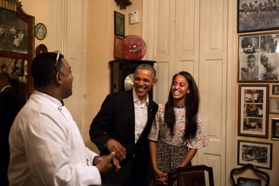 Obama shares a laugh with his daughter Malia as she interprets in Spanish for a restauranteur in Havana.