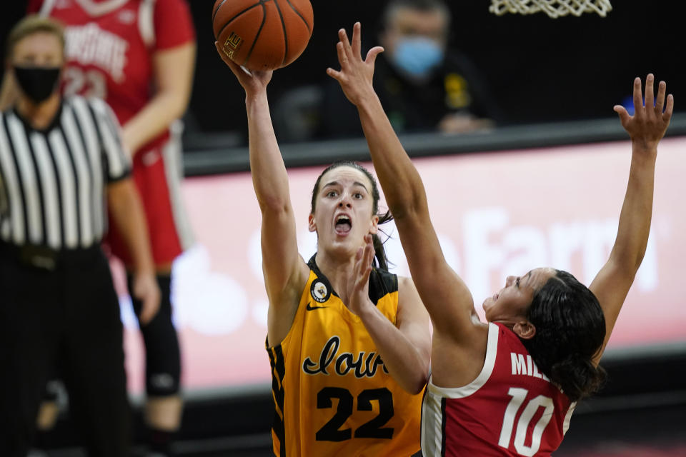 Iowa guard Caitlin Clark (22) drives to the basket ahead of Ohio State guard Braxtin Miller (10) during the first half of an NCAA college basketball game Wednesday, Jan. 13, 2021, in Iowa City, Iowa. Clark, an in-state recruit from West Des Moines Dowling High School, came to the Hawkeyes as a five-star recruit rated No. 4 nationally by ESPN. She won gold medals with the United States team at the 2017 U16 FIBA Americas Tournament and 2019 U19 FIBA World Cup Tournament. It didn’t take long for the Hawkeyes to get to know her. (AP Photo/Charlie Neibergall)