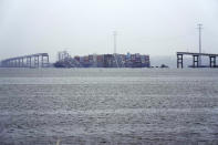 A container ship rests against the wreckage of the Francis Scott Key Bridge on Thursday, March 28, 2024, in Baltimore, Md. After days of searching through murky water for the workers missing after the bridge collapsed, officials are turning their attention Thursday to what promises to be a massive salvage operation. (AP Photo/Matt Rourke)