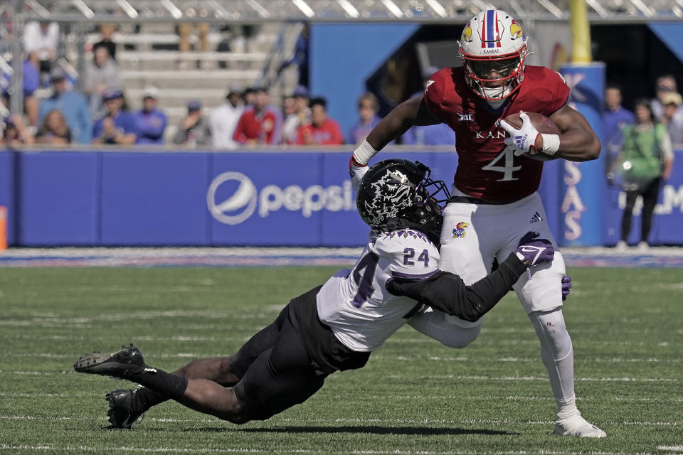 Kansas running back Devin Neal (4) is tackled by TCU cornerback Josh Newton (24) during the first half of an NCAA college football game Saturday, Oct. 8, 2022, in Lawrence, Kan. (AP Photo/Charlie Riedel)