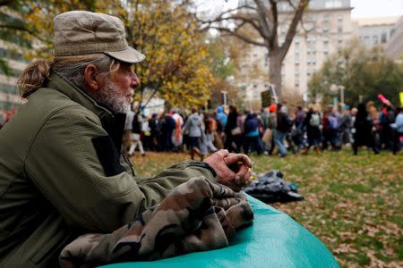 Steve Stoppelbein, a homeless man who says he has lived in Franklin Square for about a year, watches as students march out of the park for an 'Our Generation, Our Choice' protest in downtown Washington in this November 9, 2015, file photo. REUTERS/Jonathan Ernst/Files