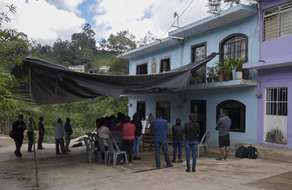 Neighbors pray for the brothers Yovani and Jair Valencia Olivares and cousin Misael Olivares in San Marcos Atexquilapan, Veracruz state, Mexico, Thursday, June 30, 2022. The three youths are missing, after it was confirmed to the family that they were traveling in the abandoned trailer in San Antonio, Texas where more than 50 bodies were found. (AP Photo/Yerania Rolon)