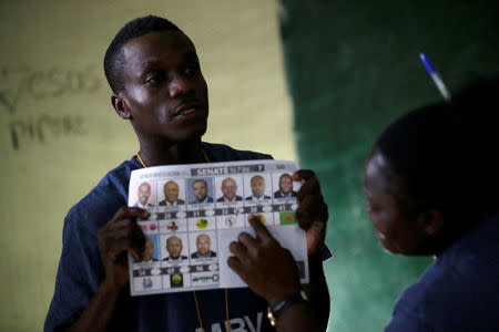 An electoral worker shows a ballot during vote counting at a polling station in Les Cayes, Haiti, November 20, 2016. REUTERS/Andres Martinez Casares
