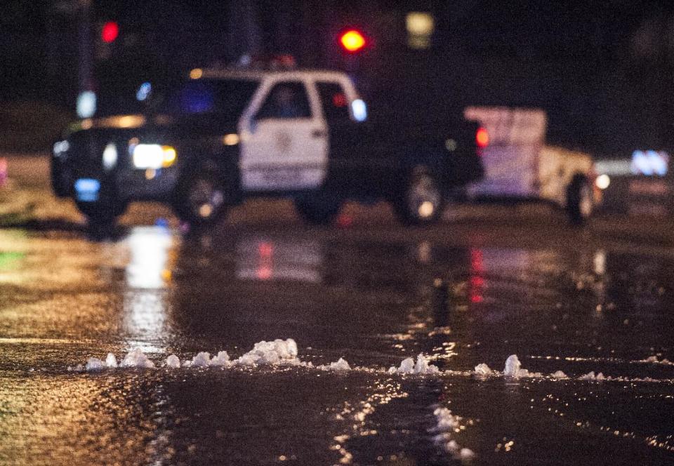 Water bubbles up through the pavement along Gilbert Street just south of Rosecrans in Fullerton Friday night March 28, 2014 following an 5.1 earthquake. Police closed off the street as crews placed cones around the area. (AP Photo/The Orange County Register, Mark Rightmire)