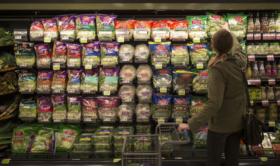 shopping for greens in bags at a grocery store