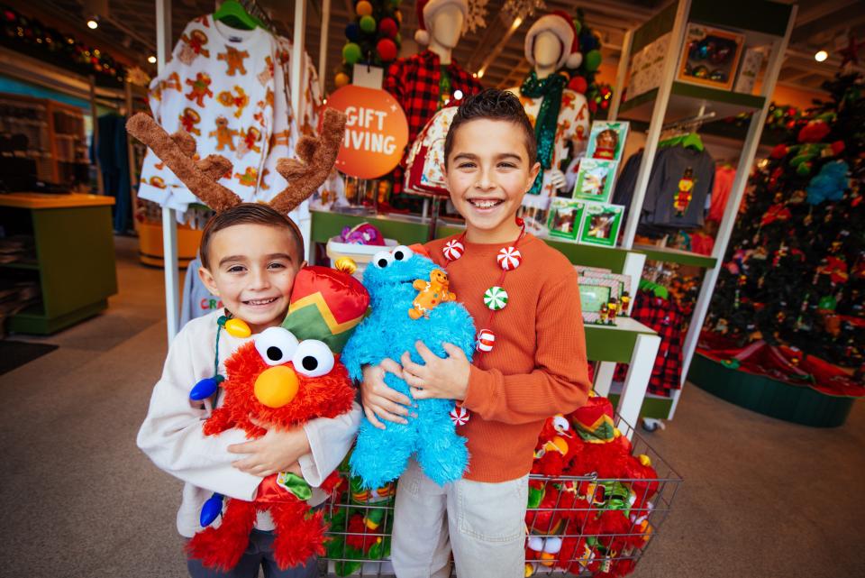 Youths hold plush toy replicas of Sesame Place characters Elmo and Cookie Monster. These toys and others like this will be available at the Sesame Pace Store, the flagship store located at the entrance of Sesame Place in Middletown. The Sesame Place Store will open this fall.