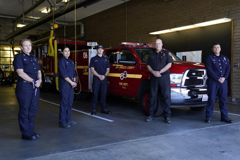 From left, fire Truck Captain Jeane Barrett, firefighter paramedic Sally Ortega, engine probationary firefighter Cole Gomoll, Battalion Chief Dean Douty, and Engine Captain Joe Peña, all first responders from Los Angeles County Fire Department - Station 106, pose for a photo at their station Friday, Feb. 26, 2021, in Rancho Palos Verdes, Calif, a suburb of Los Angeles. The crew responded to the scene of a vehicle crash involving golfer Tiger Woods on Tuesday. (AP Photo/Ashley Landis)