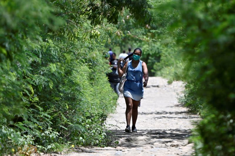 A woman wearing a face mask walks through an illegal crossing near the Simon Bolivar international bridge in Cucuta