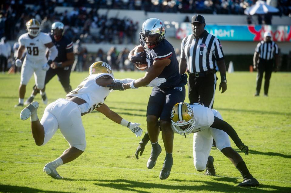 Jackson State University's Keith Corbin III (7) tries to get around Alabama State's defense during JSU's homecoming game at Mississippi Veterans Memorial Stadium in Jackson, Miss., Saturday, Oct. 16, 2021.