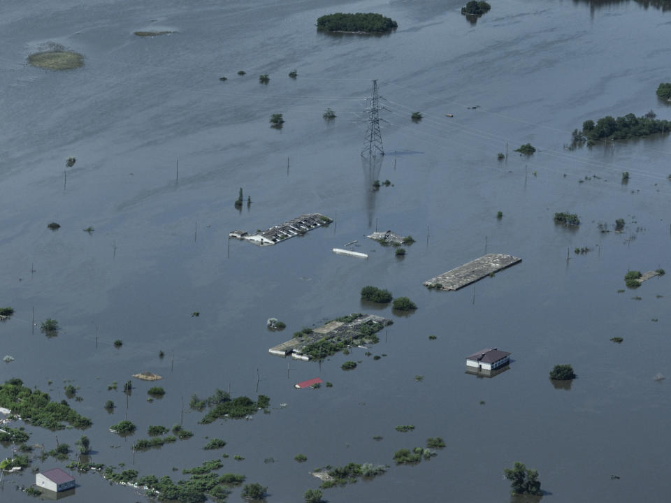 En la imagen, vista de viviendas sumergidas en la anegada localidad de Dnipryany, en territorio ucraniano ocupado por Rusia, el 7 de junio de 2023, tras el colapso de la represa de Kajovka. (AP Foto)