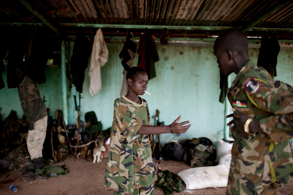 A young South Sudanese soldier who appeared to be drunk reaches for a lighter for his cigarette at the Sudan People's Liberation Army (SPLA) headquarters in Bentiu, Unity State, South Sudan on Friday, May 11, 2012. In late April, tensions between Sudan and South Sudan erupted into armed conflict along their poorly defined border. Thousands of SPLA forces have been deployed to Unity State where the two armies are at a tense stalemate around the state's expansive oil fields. Fighting between the armies lulled in early May after the U.N. Security Council ordered the countries to resume negotiations. South Sudan seceded from the Republic of Sudan in July 2011 following decades of civil war. (AP Photo/Pete Muller)