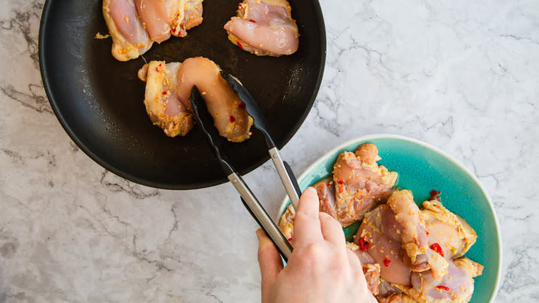 Adding chicken to pan