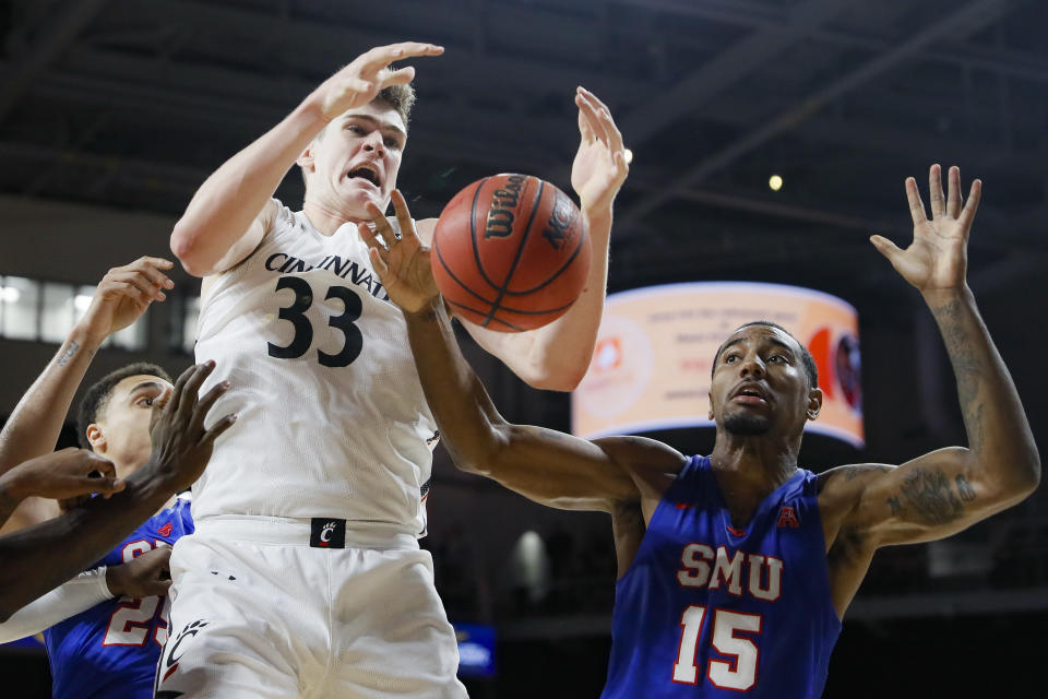 Cincinnati's Chris Vogt (33) and SMU's Isiaha Mike (15) compete for a rebound during the first half of an NCAA college basketball game Tuesday, Jan. 28, 2020, in Cincinnati. (AP Photo/John Minchillo)