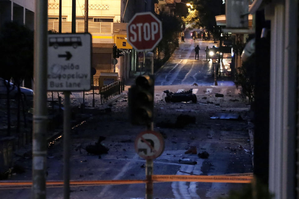 The remains of a car sit on a street after a car bomb explosion in central Athens, on Thursday, April 10, 2014. The bomb exploded outside a Bank of Greece building in central Athens before dawn Thursday, causing some damage but no injuries. The blast came hours before Greece was to return to the international bond markets for the first time in four years, and a day before German Chancellor Angela Merkel was to visit Athens.(AP Photo/ Petros Giannakouris)