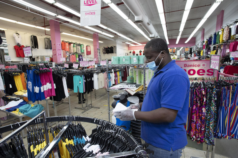 FILE - In this June 8, 2020 file photo, Danice clothing store manager Alexander Nee checks invoices as the Bronx business reopens, in New York. Restaurants, retailers and salons are desperately trying to stay afloat as the U.S. economy reopens in fits and starts after months in a coronavirus lockdown. But billions of dollars allocated by Congress as a lifeline to those very businesses are about to be left on the table when the government's Paycheck Protection Program stops accepting applications for loans Tuesday, June 29.  (AP Photo/Mark Lennihan, File)