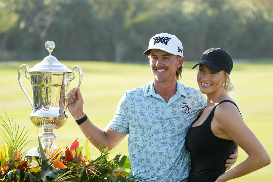 Jake Knapp, of the United States, and his girlfriend Makena White pose with his trophy during the award ceremony after winning the Mexico Open golf tournament in Puerto Vallarta, Mexico, Sunday, Feb. 25, 2024. (AP Photo/Fernando Llano)