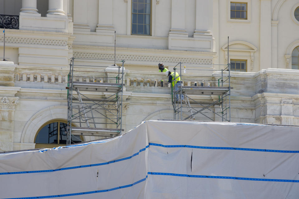 Workers on the West Front of the U.S. Capitol on Friday, Aug. 7, 2020, in Washington. While much of Washington is twisted in knots over the upcoming election, there’s another contingent already busy trying to figure out how to stage an inauguration for the next president during a pandemic. (AP Photo/Jon Elswick)