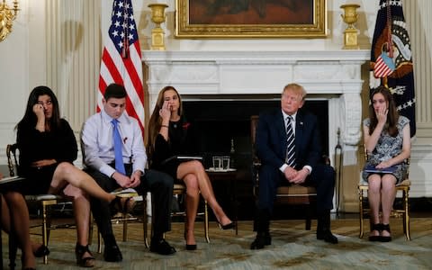 Florida school shooting survivors Jonathan Blank and Julia Cordover, centre, listen along with President Trump - Credit: JONATHAN ERNST/REUTERS