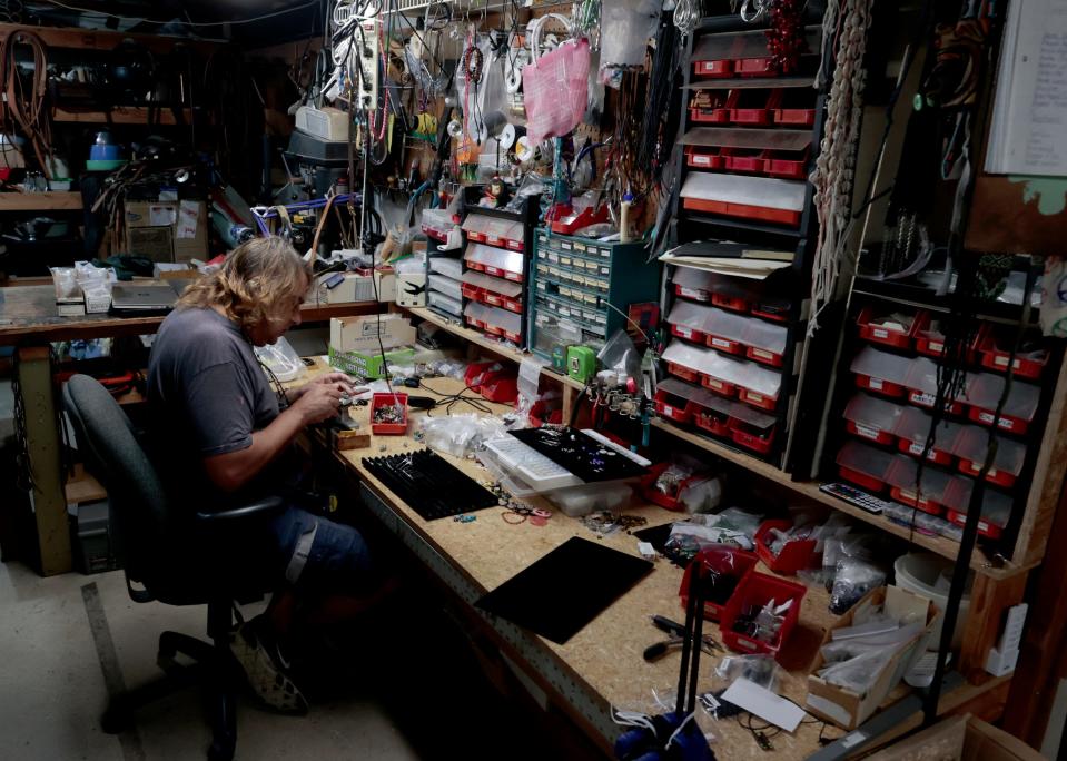 Paul Rudy, 56, of St. Clair Shores, sits in his basement on Wednesday, Aug. 23, 2023, making earrings in the same spot where he usually makes eyeglass straps. His De Suave line of straps are popular on Amazon, Etsy and they are for sale at Eastern Market in Detroit as well.